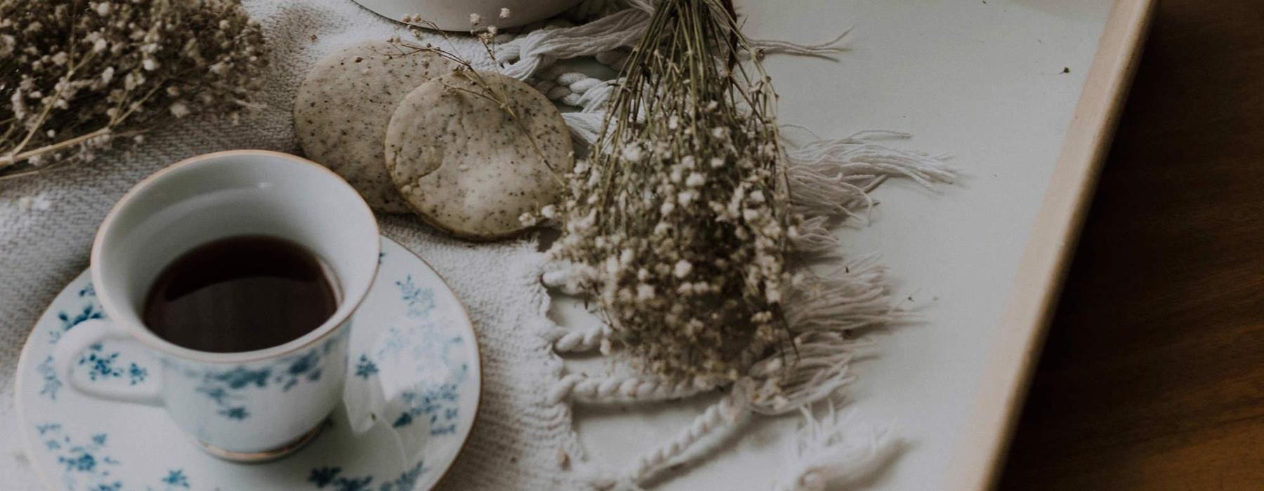 tea and cookies on a serving tray with baby's breath