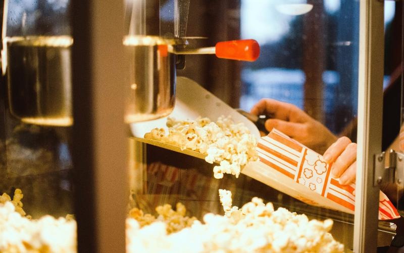 a person pouring popcorn into a container