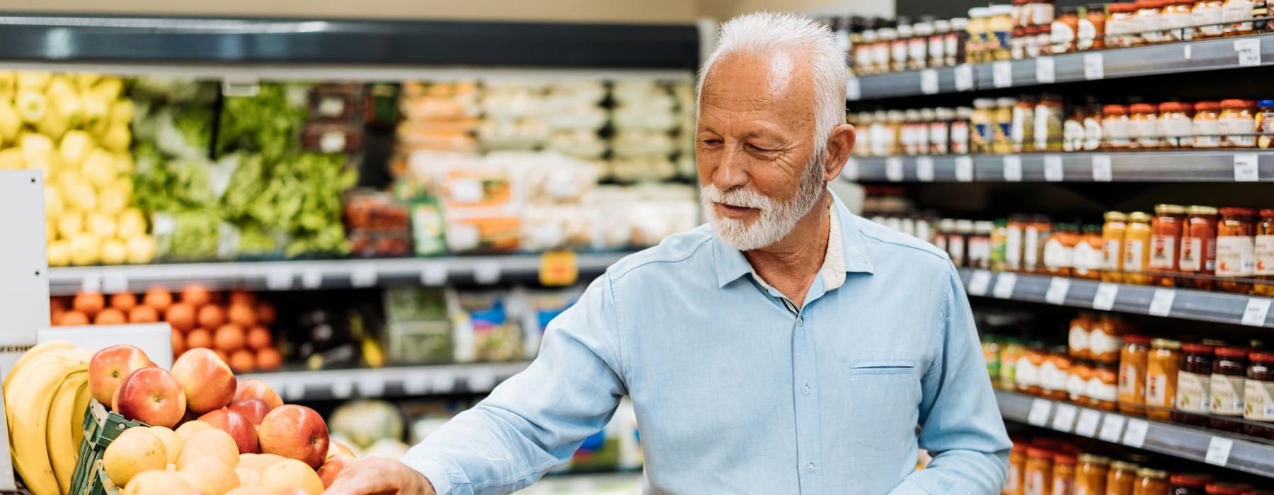 a person holding a shopping cart in a grocery store